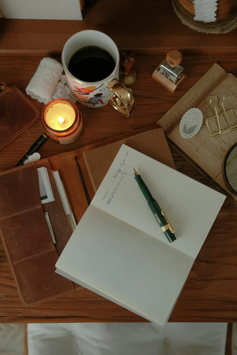 Een bureau met een notitieboek, een pen en een kop koffie